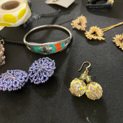 Assortment of vintage costume jewelry, including beaded dangle earrings, a silver-tone cuff bracelet with turquoise-colored inlay, and...