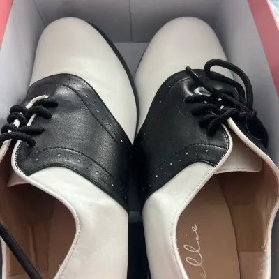 Pair of Ellie brand black and white saddle shoes in their original box, showing minimal wear.