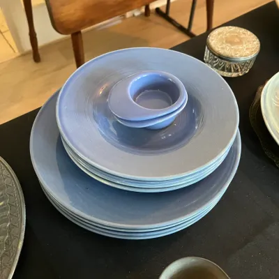 Vintage Russell Wright periwinkle blue dinnerware set, including dinner plates, salad plates, and small bowls.