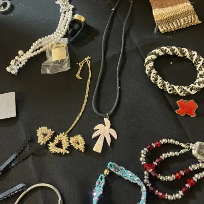 Assortment of vintage costume jewelry, including a palm tree pendant necklace, beaded bracelets, a gold-tone rhinestone necklace, and a...