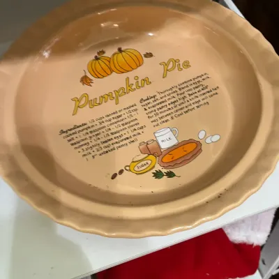 Vintage ceramic pumpkin pie baking dish featuring a printed recipe, fluted edge, and pumpkin illustrations, circa 1970s or 1980s.