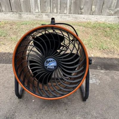 Maxx Air Pro industrial floor fan with an orange and black housing, showing some light wear from use.