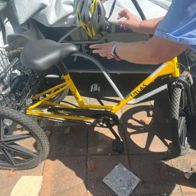 Sun Atlas yellow adult tricycle featuring a large rear wire basket, heavy-duty mag wheels, and a wide comfort seat.