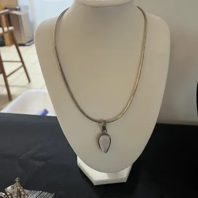 Sterling silver omega chain necklace featuring a teardrop-shaped moonstone pendant, displayed on a white bust.