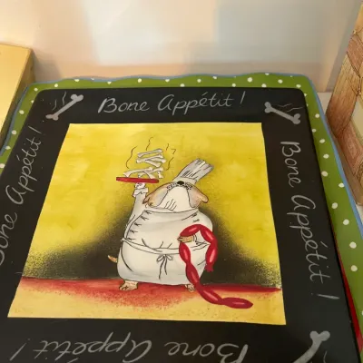 Whimsical square ceramic serving platter featuring a dog chef illustration, inscribed with "Bone Appétit!" along the black border.
