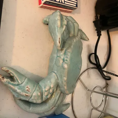 Vintage light blue glazed ceramic crab figurine featuring a crackle finish, showing some minor wear on the claws.