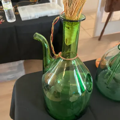 Vintage green glass porron wine decanter with an ice chamber, featuring a straw stopper.