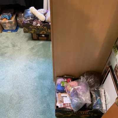 Boxes and plastic bins filled with assorted crafting yarn and knitting supplies.