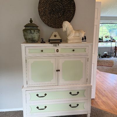 Sale Photo Thumbnail #15: Vintage painted wood armoire featuring a white and mint green finish, two upper drawers, a double-door cabinet, and two lower drawers with ornate metal pulls.
