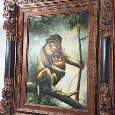 Sale Photo Thumbnail #3: Oil painting depicting a mother monkey and her baby in a jungle setting, signed 'MENGALI' and housed in an ornate, heavily carved gilt and black frame.