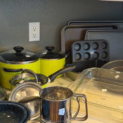 Sale Photo Thumbnail #23: Assorted kitchenware including lime green Tivoli pots, a stainless steel flour sifter, Pyrex baking dishes, and various metal baking sheets.