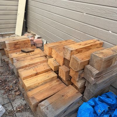 Sale Photo Thumbnail #44: Stack of reclaimed wooden beams and posts of various lengths, showing natural weathering and grain patterns.