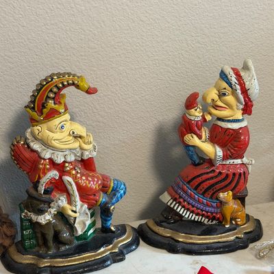Sale Photo Thumbnail #34: Pair of vintage cast iron Punch and Judy doorstops, featuring hand-painted details with some paint wear consistent with age.