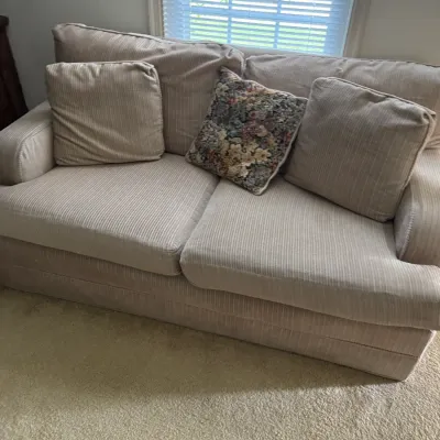 Sale Photo Thumbnail #153: Beige corduroy-textured loveseat with matching throw pillows and a central floral tapestry accent pillow, showing light wear.