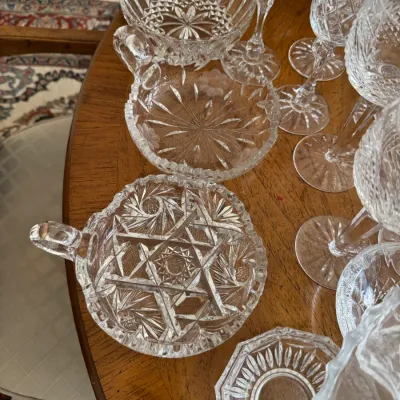 Sale Photo Thumbnail #112: Collection of vintage cut glass and crystal tableware, including handled nappy dishes with starburst patterns and coordinating stemware.