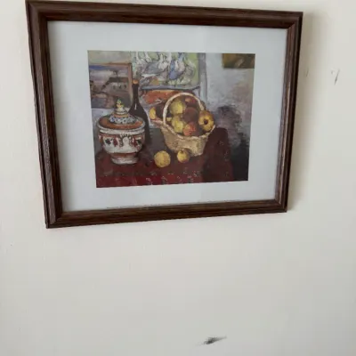 Sale Photo Thumbnail #113: Framed still life art print depicting a basket of fruit and a decorative lidded jar, presented in a dark wood frame with a white mat.