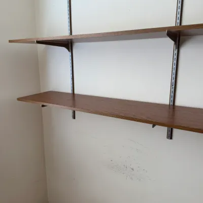 Wall-mounted shelving system featuring two wood-look laminate shelves supported by adjustable metal standards and brackets.