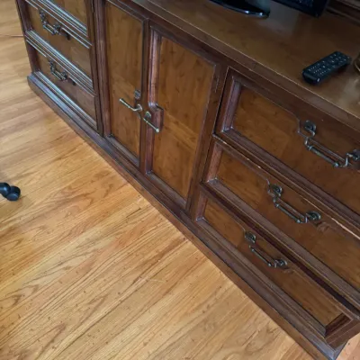 Vintage wooden credenza or dresser featuring a central double-door cabinet flanked by three drawers on each side, complete with ornate...