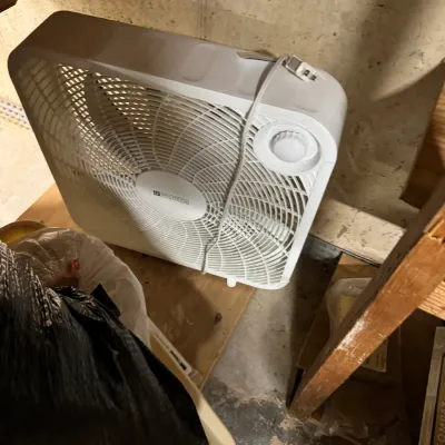 Utilitech white plastic box fan with top-mounted control dial, showing light wear from use.