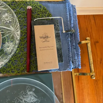 Sale Photo Thumbnail #124: Willow Tree "Surrounded by Love" figurine in its original Demdaco box, displayed alongside a green marble cheese slicer and other tabletop decor.