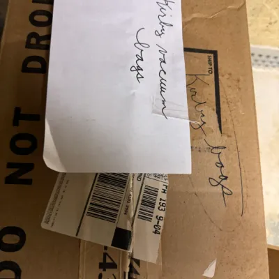 Cardboard box labeled "Kirby vacuum bags" containing replacement vacuum cleaner bags.