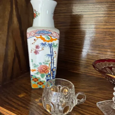 Sale Photo Thumbnail #165: Japanese Imari-style porcelain vase with floral and bamboo motifs, paired with a small pressed glass cup featuring gold-painted thumbprint details.