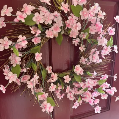 Sale Photo Thumbnail #156: Decorative spring wreath featuring faux pink cherry blossoms and green leaves on a natural twig base, hanging on a red door.