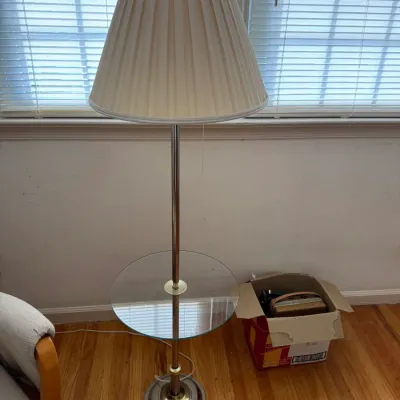 Vintage brass and chrome floor lamp featuring an integrated circular glass tray table and a pleated cream fabric shade.