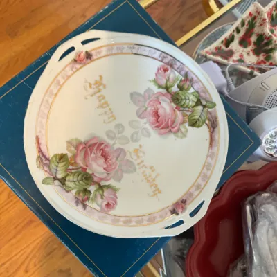 Sale Photo Thumbnail #123: Vintage porcelain cake plate featuring pink roses, gold-tone accents, and "Happy Birthday" script, complete with integrated handles.