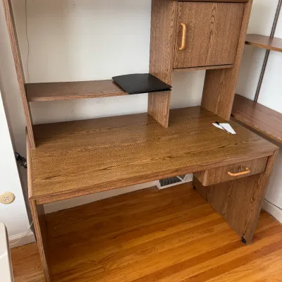Vintage oak laminate student desk with an integrated hutch, featuring a small storage cabinet, open shelving, and a single drawer.