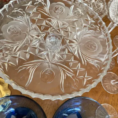 Sale Photo Thumbnail #110: Vintage pressed glass cake stand featuring a frosted rose and cut-glass starburst pattern with a scalloped rim.