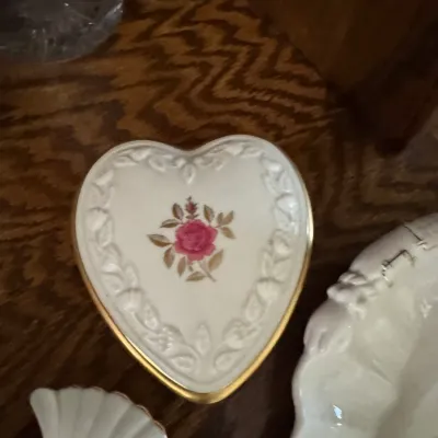 Sale Photo Thumbnail #192: Vintage Lenox heart-shaped porcelain trinket box featuring a pink rose motif, embossed leaf border, and gold-trimmed edge.