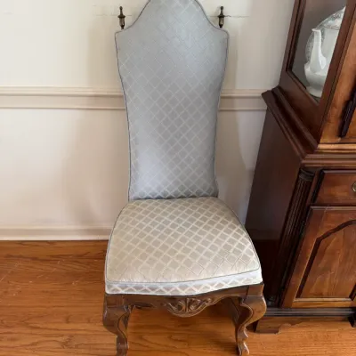Sale Photo Thumbnail #127: Vintage high-back dining chair featuring a carved wood frame with cabriole legs, upholstered in a light blue and cream diamond-patterned fabric.