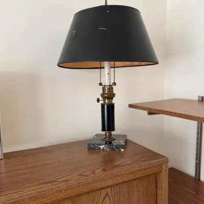 Vintage table lamp featuring a black column body, brass accents, and a marble base, topped with a black paper shade.