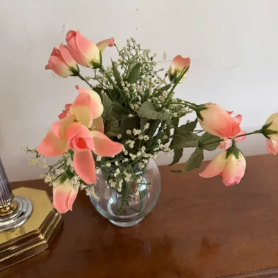 Sale Photo Thumbnail #186: Faux floral arrangement featuring pink roses and baby's breath in a small, round glass vase.