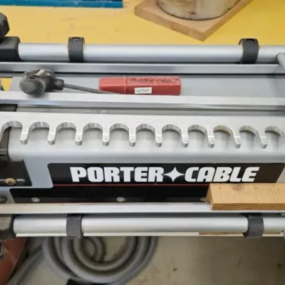 Porter-Cable dovetail jig with aluminum template and adjustment knobs, showing light signs of workshop use.