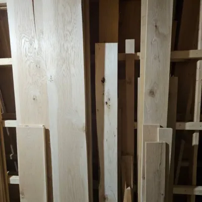 Assorted unfinished hardwood lumber boards in various lengths and widths, suitable for woodworking projects.