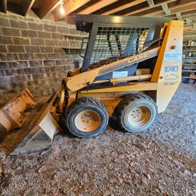 Case 1840 skid steer loader with front bucket attachment, showing some wear from use.
