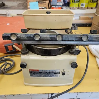 Vintage Makita model 9820-2 electric blade sharpener, showing some dust and wear from workshop use.