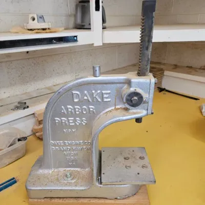Vintage Dake No. 1 arbor press, manufactured by Dake Engine Co. in Grand Haven, Michigan, featuring a cast iron frame with silver paint.
