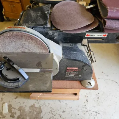 Craftsman 6 x 9-inch belt and disc sander with dust collection, showing some wear and dust from use, accompanied by extra sanding discs...