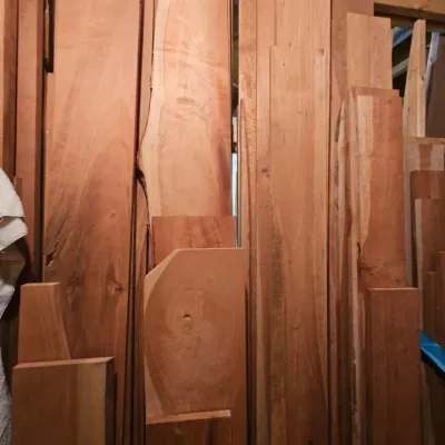 Assorted cherry and hardwood lumber planks in various lengths and widths, suitable for woodworking projects.
