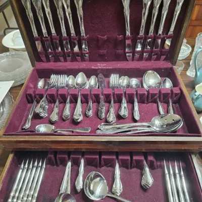 Vintage  flatware set by Home Decorators, housed in a two-tier wooden storage chest lined with purple felt.