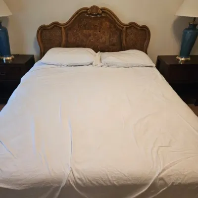 Vintage French Provincial style headboard featuring a burl wood center panel, woven cane side inserts, and a carved wood frame.