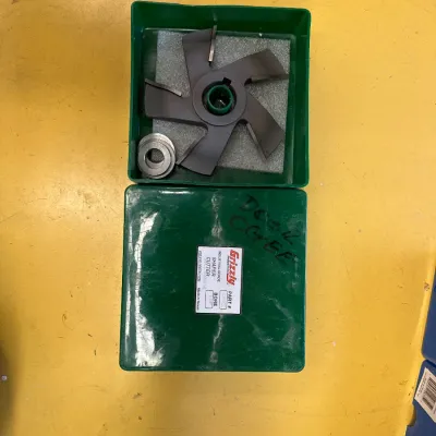 Grizzly Industrial shaper cutter with spacers, housed in its original green plastic storage case.