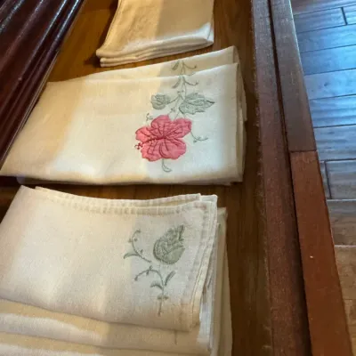 Sale Photo Thumbnail #221: Assorted vintage linen napkins and hand towels with embroidered floral details, neatly folded inside a wooden drawer.