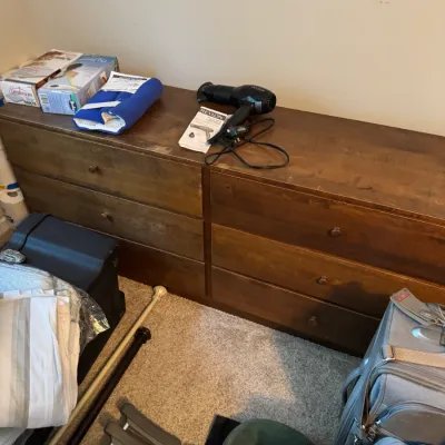 Sale Photo Thumbnail #169: Mid-century style six-drawer wooden dresser, shown with various household items including a Revlon hair dryer, Sunbeam heating pads, and luggage.