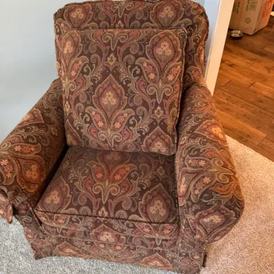 Sale Photo Thumbnail #261: Traditional upholstered armchair and matching throw pillow featuring a warm-toned paisley pattern in shades of brown, rust, and gold.