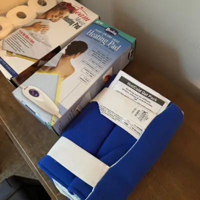 Sale Photo Thumbnail #136: Assortment of personal care items including a blue hot/cold gel pack, a Dunlop moist or dry heating pad in its original box, and a Sunbeam moist heating pad.