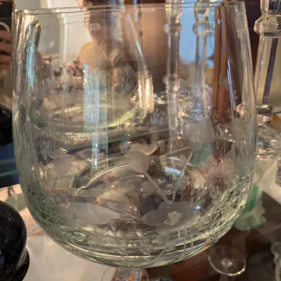 Sale Photo Thumbnail #246: Large clear glass bowl featuring an etched floral and vine pattern, shown displayed on a glass shelf alongside crystal candlesticks.